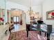 Spacious living area with grand piano, chandelier, and large windows, perfect for entertaining or relaxation at 254 Sylvan Blvd, Winter Park, FL 32789