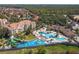 Aerial view of a community swimming pool, water slides, resort-style amenities, surrounded by lush greenery at 2683 Manesty Ln, Kissimmee, FL 34747