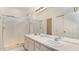 Bright bathroom featuring double sinks, a large mirror, and a glass-enclosed shower at 2683 Manesty Ln, Kissimmee, FL 34747