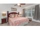 Charming bedroom with a ceiling fan, a large window, and a queen-sized bed adorned with sea-themed linens and pillows at 2683 Manesty Ln, Kissimmee, FL 34747