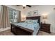 Comfortable bedroom features a ceiling fan, a dark wooden dresser with lamp and a bed decorated with sea-themed linens at 2683 Manesty Ln, Kissimmee, FL 34747