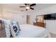 This bedroom includes a queen bed, a ceiling fan, a dresser with a mirror and television at 2683 Manesty Ln, Kissimmee, FL 34747