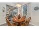 Cozy breakfast nook with wood chairs and table, adjacent to sliding glass doors and the kitchen at 2683 Manesty Ln, Kissimmee, FL 34747