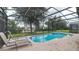 Screened-in pool with spa and lounge chairs overlooking the backyard at 2683 Manesty Ln, Kissimmee, FL 34747