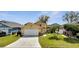 Charming single-story home featuring a well-maintained lawn, mature palm trees, and an attached two-car garage at 3084 Stillwater Dr, Kissimmee, FL 34743