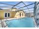 Home featuring a sparkling blue swimming pool with screened enclosure and ample patio space at 3084 Stillwater Dr, Kissimmee, FL 34743