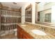 Bathroom features double vanity with granite countertop and shower with neutral toned tile at 3623 S Saint Lucie Dr, Casselberry, FL 32707