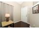 Entryway featuring dark wood floors, a white door, warm lighting, and a decorative wall hanging at 3623 S Saint Lucie Dr, Casselberry, FL 32707