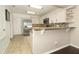 Open kitchen featuring stainless steel refrigerator, white cabinets, and granite countertops at 3623 S Saint Lucie Dr, Casselberry, FL 32707