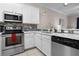 Kitchen with white cabinets, stainless steel appliances, tile backsplash, and marble countertops at 505 Rum Run # 505, Davenport, FL 33897