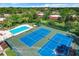 A captivating aerial view showcasing the community's tennis courts, sparkling pool, and lush green surroundings at 5401 Elm Ct # 303, Orlando, FL 32811