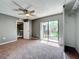 Bedroom with ceiling fan, sliding glass doors to balcony, and neutral colored carpet at 5401 Elm Ct # 303, Orlando, FL 32811