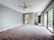 Spacious main bedroom with sliding glass doors that lead to a balcony, providing ample natural light at 5401 Elm Ct # 303, Orlando, FL 32811