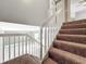 View of the staircase leading down to the tiled floors, with grey walls and white railings at 5401 Elm Ct # 303, Orlando, FL 32811