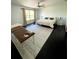 Bright bedroom with a ceiling fan, large window, dark wood floors, and a massage table at 548 Big Sioux Ct, Kissimmee, FL 34759