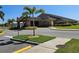 A tan colored clubhouse with a portico and several palm trees on a sunny day with well-maintained landscaping at 548 Big Sioux Ct, Kissimmee, FL 34759