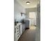 Bright laundry room includes white cabinetry, shelving, modern washer, and decorative rug at 548 Big Sioux Ct, Kissimmee, FL 34759