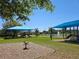 Community playground shaded by canopies featuring swings, slides, and a water fountain on a sunny day at 548 Big Sioux Ct, Kissimmee, FL 34759