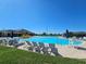 Community swimming pool featuring lounge chairs, a water slide and a lifeguard stand on a sunny day at 548 Big Sioux Ct, Kissimmee, FL 34759