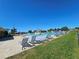 An outdoor community swimming pool featuring lounge chairs, a water slide, and picnic tables on a sunny day at 548 Big Sioux Ct, Kissimmee, FL 34759