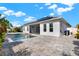 A view of the backyard featuring a sparkling pool, screened-in patio, modern patio pavers and solar panels at 5499 Orange Orchard Dr, Winter Garden, FL 34787