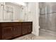 Modern bathroom with double vanity sinks, quartz countertops, and a glass-enclosed shower at 5499 Orange Orchard Dr, Winter Garden, FL 34787