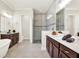 Bright bathroom featuring a large glass shower, dual vanities and sinks, and tile floors at 5499 Orange Orchard Dr, Winter Garden, FL 34787