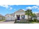 Charming single-story home with a manicured lawn, paver driveway and vibrant blue front door at 5499 Orange Orchard Dr, Winter Garden, FL 34787