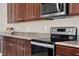Kitchen close up featuring granite countertops, stainless steel appliances, and wood cabinets at 5499 Orange Orchard Dr, Winter Garden, FL 34787