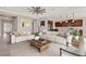 Bright living room featuring a spacious sectional sofa, modern ceiling fan and view into the kitchen at 5499 Orange Orchard Dr, Winter Garden, FL 34787