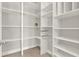 Bright walk-in closet with custom white shelving and organizers, providing efficient storage solutions at 5499 Orange Orchard Dr, Winter Garden, FL 34787