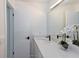 Clean bathroom with white cabinets, quartz countertop, large mirror, and decorative plant at 7549 Dockside St, Winter Park, FL 32792