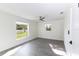 Bright bedroom with grey wood-look floors, ceiling fan, two windows letting in natural light and freshly painted white walls at 7549 Dockside St, Winter Park, FL 32792