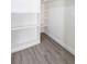 Walk-in closet features wood-look flooring and built-in shelving for optimized storage space at 7549 Dockside St, Winter Park, FL 32792