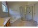 Bright bathroom features a soaking tub, glass enclosed shower, and single window for natural light at 781 Lakeworth Cir, Lake Mary, FL 32746