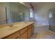Bright bathroom features a double sink vanity, large mirror, corner soaking tub, and a glass enclosed shower at 781 Lakeworth Cir, Lake Mary, FL 32746