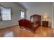 Spacious bedroom features an empty, decorative wooden bedframe, wood floors, and natural light from two windows at 781 Lakeworth Cir, Lake Mary, FL 32746