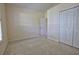 This bright bedroom features a neutral color palette, plush carpeting, and a closet at 781 Lakeworth Cir, Lake Mary, FL 32746