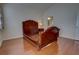 Spacious bedroom features an empty, decorative wooden bedframe, wood floors, and a view into the ensuite bath at 781 Lakeworth Cir, Lake Mary, FL 32746