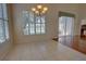 Dining area featuring tile floors, sunlit windows with shutters, and a modern chandelier overlooking the lake at 781 Lakeworth Cir, Lake Mary, FL 32746