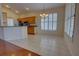 Kitchen featuring wood cabinetry, tile floors, stainless steel appliances, and a sunlit dining area at 781 Lakeworth Cir, Lake Mary, FL 32746