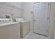 Laundry room featuring a white washer and dryer, and a wire rack for convenient storage at 781 Lakeworth Cir, Lake Mary, FL 32746