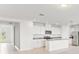 Bright kitchen with granite countertops, island, stainless appliances, and white cabinetry at 792 Griffon Ave, Lake Alfred, FL 33850