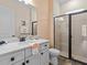 Clean bathroom featuring quartz countertop, white cabinetry, and glass door shower at 8086 Knee Deep Rd, Kissimmee, FL 34747
