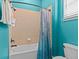 Bathroom featuring white tub, tiled surround, and a wood-look shower curtain at 8086 Knee Deep Rd, Kissimmee, FL 34747