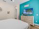Bright bedroom with hardwood floors, TV, and white wood four-poster bed frame at 8086 Knee Deep Rd, Kissimmee, FL 34747