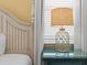 Bedroom detail with a decorative lamp on a blue bedside table by the bed at 8086 Knee Deep Rd, Kissimmee, FL 34747
