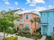 Two-story colorful home with a balcony, lush landscaping, and accessible parking at 8086 Knee Deep Rd, Kissimmee, FL 34747