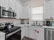 Well-lit kitchen with white cabinetry, stainless steel appliances, and light countertops at 8086 Knee Deep Rd, Kissimmee, FL 34747