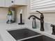 Close-up of a kitchen sink with bronze faucet and white quartz countertops at 8086 Knee Deep Rd, Kissimmee, FL 34747